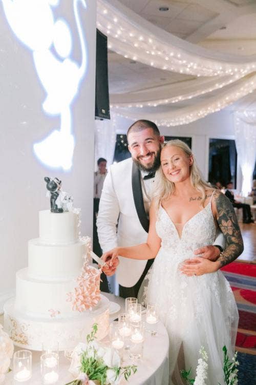 bride and groom, couple, portrait, cutting cake, cake, wedding reception, reception, 3 tier cake, Disneyland, Disneyland Hotel, sleeping beauty, sleeping beauty pavilion