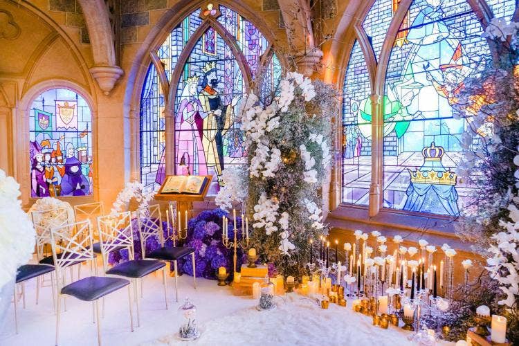 decorated wedding ceremony, wedding ceremony, ceremony, venue, sleeping beauty castle, castle, stain glass, stain glass windows, custom chairs, altar area, altar candles, disneyland