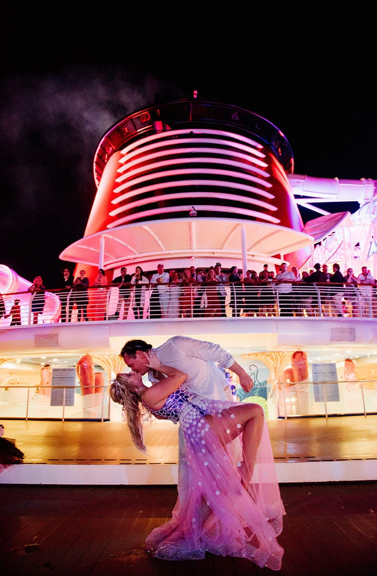 A bride and groom kissing on the deck of the Disney Cruise Line