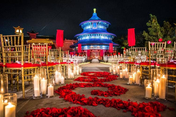 decorated wedding ceremony, ceremony, wedding ceremony, aisle decor, aisle floral, custom aisle floral, aisle candles, red roses, red floral, epcot, china, china pavilion, custom chairs