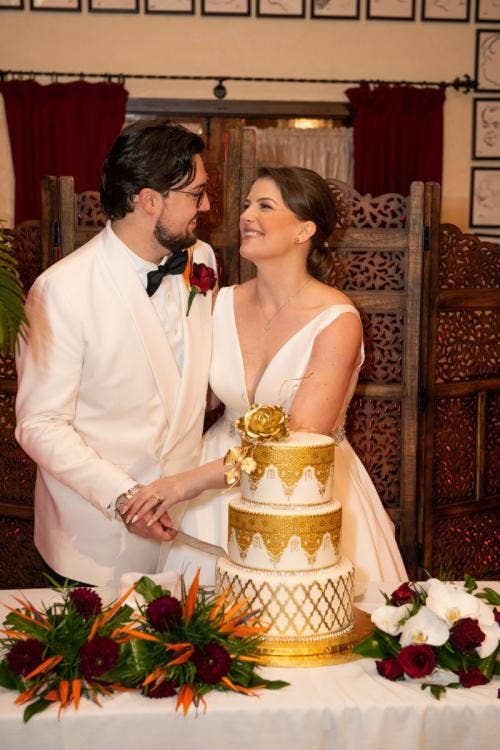 bride and groom, couple, cutting cake, wedding cake, cake, candid, wedding reception, reception, hollywood studios, brown derby, brown derby reception, gold cake