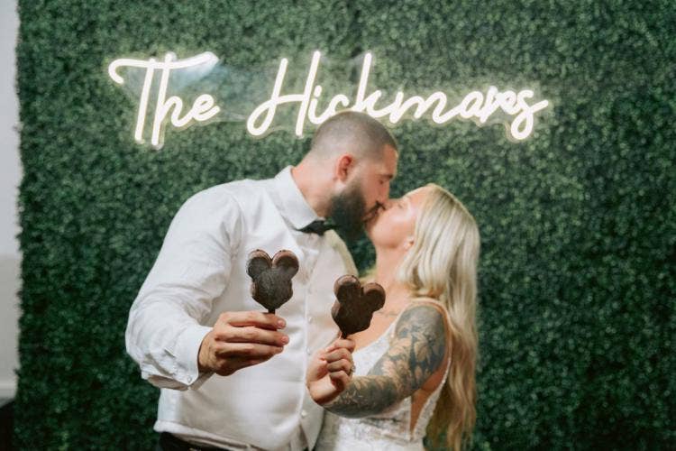 bride and groom, couple, portrait, wedding reception, reception, greenery wall, decor, reception decor, reception floral, mickey ice cream bar, mickey bar, dessert