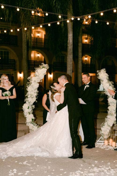 bride and groom, couple, first kiss, kiss, altar, altar area, altar arch, floral arch, altar floral, white floral, Coronado, Coronado springs, casitas, casitas courtyard
