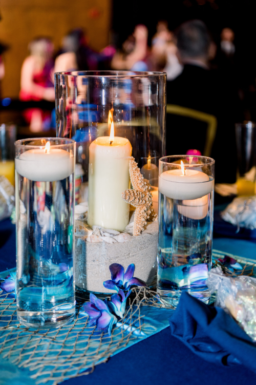 wedding reception, reception, reception decor, reception tables, table decor, centerpieces, table centerpieces, sea, sea theme, under the sea, floating candles, candles, living seas, living seas salon, epcot, living seas reception, custom centerpieces