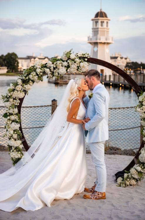 bride and groom, couple, first kiss, kiss, altar area, altar arch, yacht and beach club, yacht and beach, crescent cove, beach, waterfront