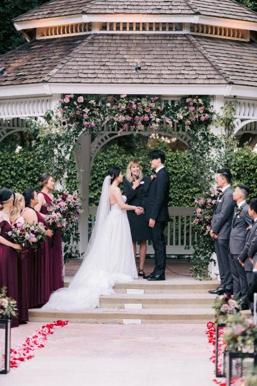 bride and groom, couple, wedding ceremony, ceremony, exchanging vows, vows, candid, altar area, altar decor, disneyland, disneyland hotel, disneyland resort, rose court, rose court garden
