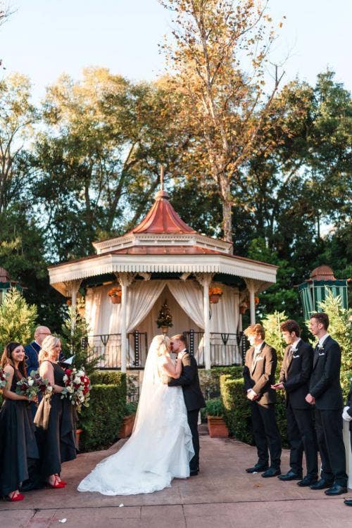 bride and groom, couple, wedding ceremony, ceremony, first kiss, Epcot, uk, uk courtyard, uk pavilion, christmas, Christmastime, christmas decor, gazebo, uk gazebo, holiday, holiday decor