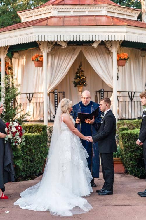 bride and groom, couple, wedding ceremony, ceremony, Epcot, uk, uk courtyard, uk pavilion, christmas, Christmastime, holiday, holiday decor, exchanging vows, vows
