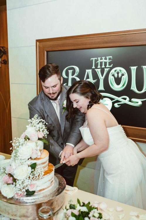 couple, cutting cake, cake, wedding cake, wedding reception, reception, the bayou, Disney wish, Disney cruise line, cruise wedding