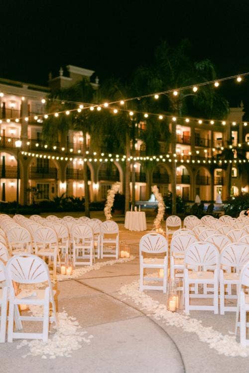 wedding ceremony, ceremony, ceremony decor, decorated ceremony, altar arch, floral arch, altar floral, white floral, string lights, aisle floral, aisle decor, aisle candles, candles, Coronado, Coronado springs, casitas, casitas courtyard