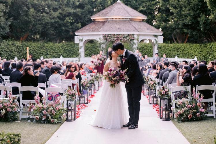 bride and groom, couple, wedding ceremony, ceremony, staged exit, exit, kiss, exit kiss, candid, moody floral, moody aesthetic, disneyland hotel, disneyland, disneyland resort, rose court, rose court garden