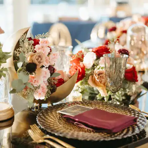 Wedding reception table setting with floral centerpieces and a decorative plate at Sea Breeze Point