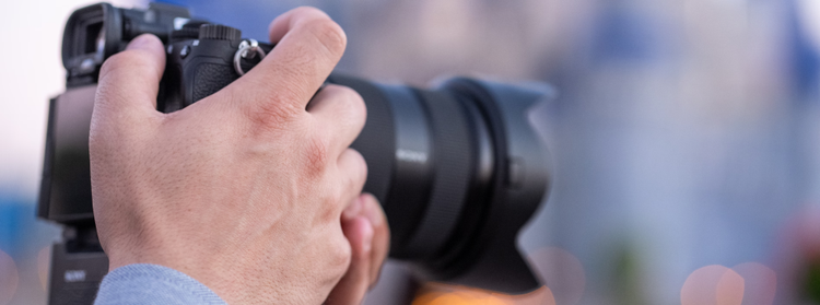 The hands of a photographer holding a professional camera