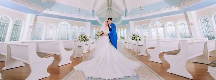 A couple in wedding attire stand in the middle of the elegant Disney‘s Wedding Pavilion at Walt Disney World Resort in Florida