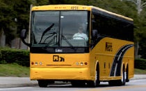 A yellow motor coach ready for guest transport at Walt Disney World Resort