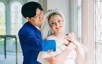 A smiling couple near a window inside Disney's Wedding Pavilion