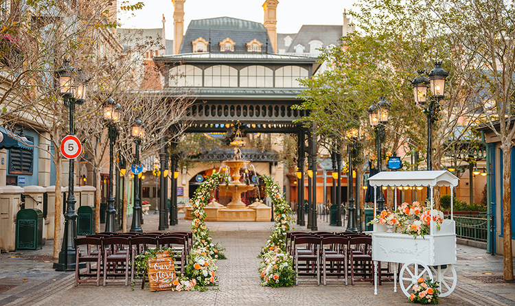 Two sections of chairs flanking an aisle and a flower cart in the France Pavilion