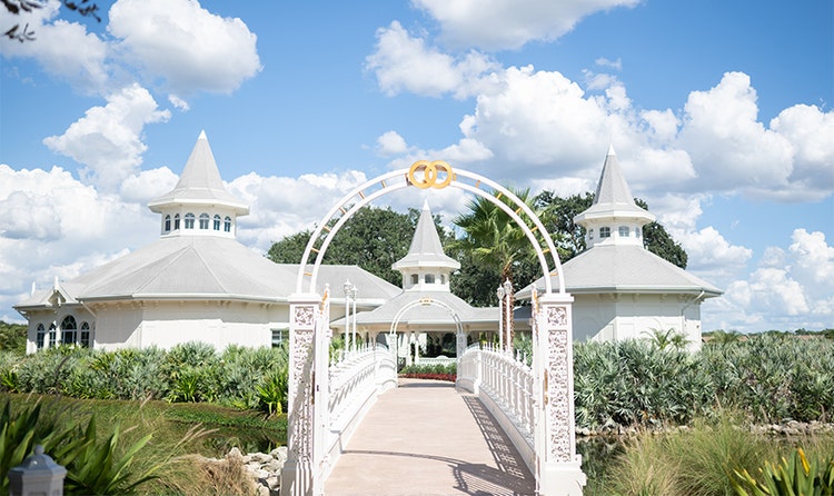 An ornate bridgeway with arches leads to Disney’s Wedding Pavilion, a compound of 3 buildings with spiral rooftops at Disney’s Grand Floridian Hotel & Spa
