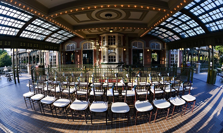 Three rows of chairs arranged on a covered balcony