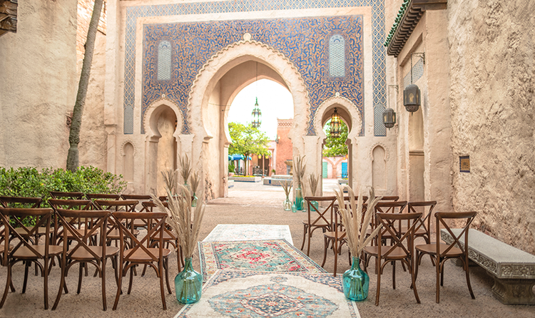 3 small rows of chairs surrounding a wedding aisle that leads to a Moroccan themed archway in the Morocco Pavilion at EPCOT