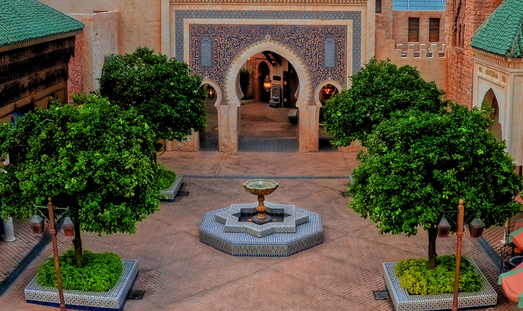 A courtyard with a tiled fountain and Moroccan themed archway in the Morocco Pavilion at EPCOT