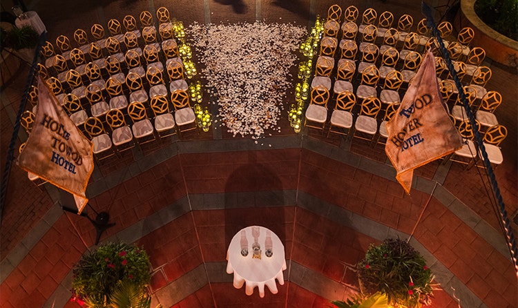 Two flags that say ‘Hollywood Tower Hotel’ above an altar and several rows of chairs