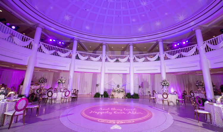 The entrance to The American Adventure framed with flowers and lanterns around the front doors