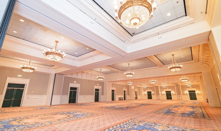 A spacious ballroom at Disney's BoardWalk Inn featuring high ceilings and chandeliers