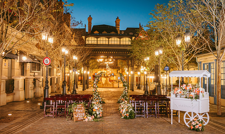 Two sections of chairs flanking an aisle and a flower cart in the France Pavilion