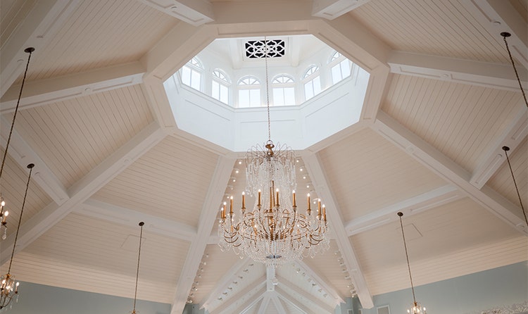 A chandelier dangles from a skylit roof inside a chapel at Disney’s Wedding Pavilion