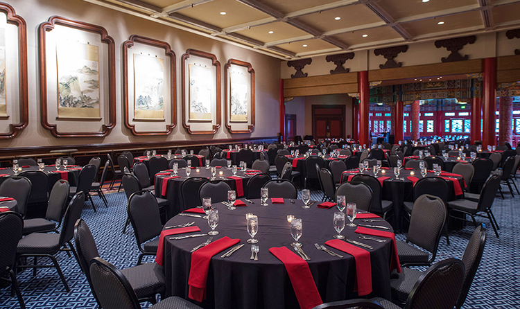 A wedding banquet room with Chinese inspired décor, furnished with several tables and chairs
