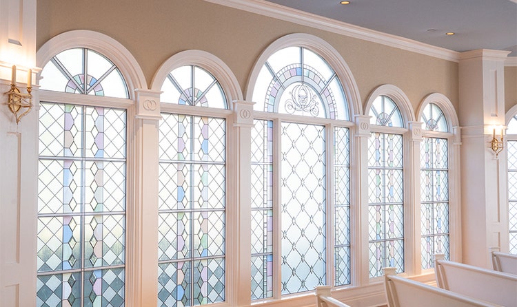 A wall of arched, stained-glass windows at Disney’s Wedding Pavilion