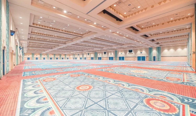 A very large ballroom with colorful carpeting and decor themed to the beauty of Spanish, Mexican and American Southwestern influences.