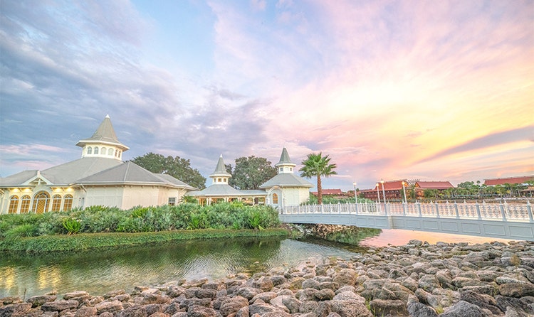 A bridge reaches across a narrow section of Seven Seas Lagoon toward Disney’s Wedding Pavilion