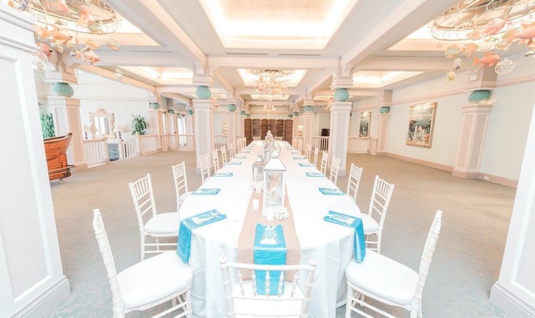 A long room with pillars extending to the ceiling and a table in the center
