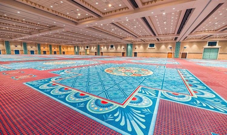A very large ballroom with colorful carpeting and decor themed to the beauty of Spanish, Mexican and American Southwestern influences.