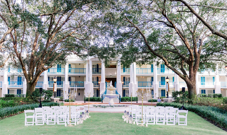 Rows of chairs set up on a lawn facing a decorative water fountain in Disney’s Port Orleans Resort Riverside