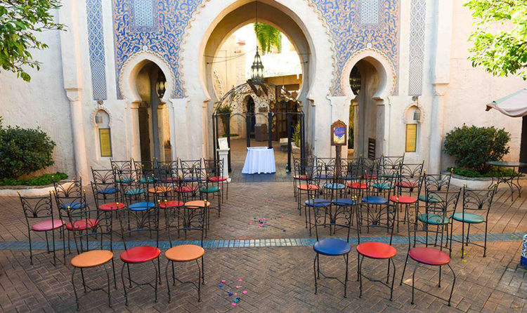 5 small rows of chairs surrounding a wedding aisle that leads to a Moroccan themed archway in the Morocco Pavilion at EPCOT