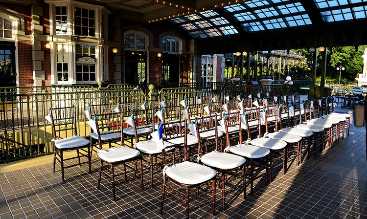 Three rows of chairs arranged near a staircase on a covered balcony