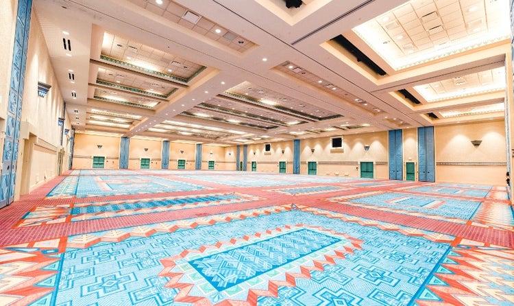 A very large ballroom with colorful carpeting and decor themed to the beauty of Spanish, Mexican and American Southwestern influences.