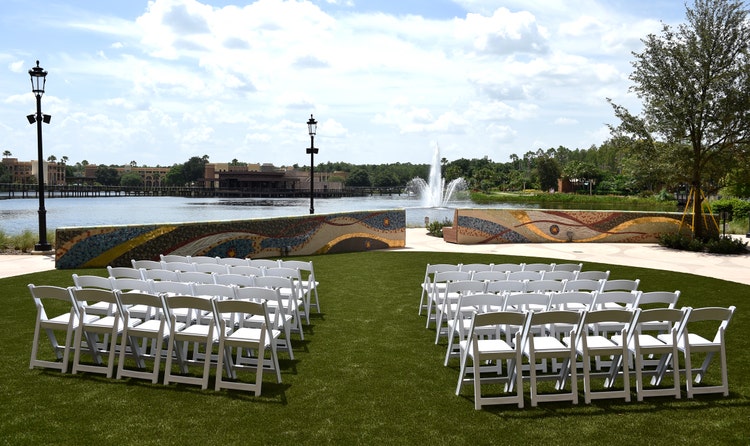 Two sets of chairs on the lawn facing a large body of water