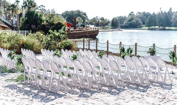 Several rows of chairs on a beach facing the water
