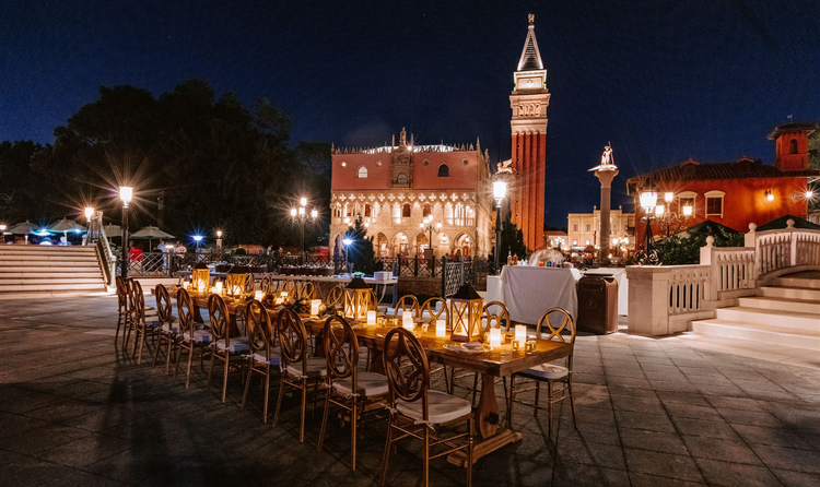 A long table, set for a wedding reception amid the Italian style buildings of Italy Isola in EPCOT at night