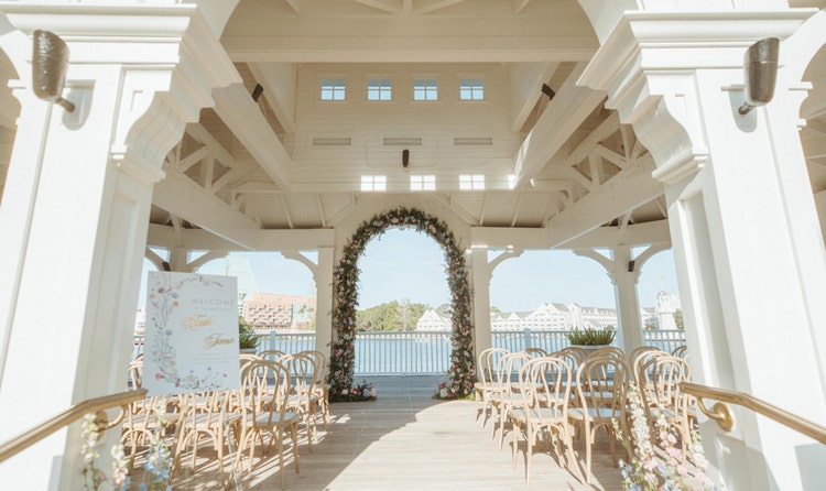A wedding ceremony venue with bentwood chairs and a floral arch in a gazebo at Seabreeze Point, looking out over Crescent Lake