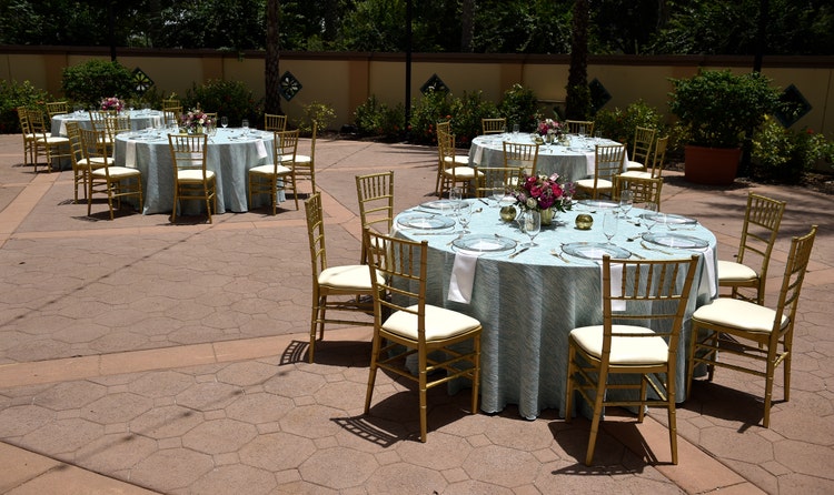Four circular tables, each with 8 place settings and a large floral centerpiece