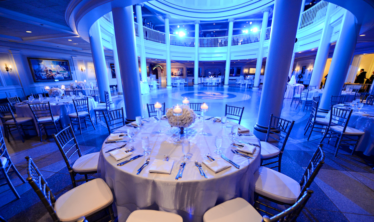 A spacious rotunda featuring large pillars and tables surrounding the center of the room