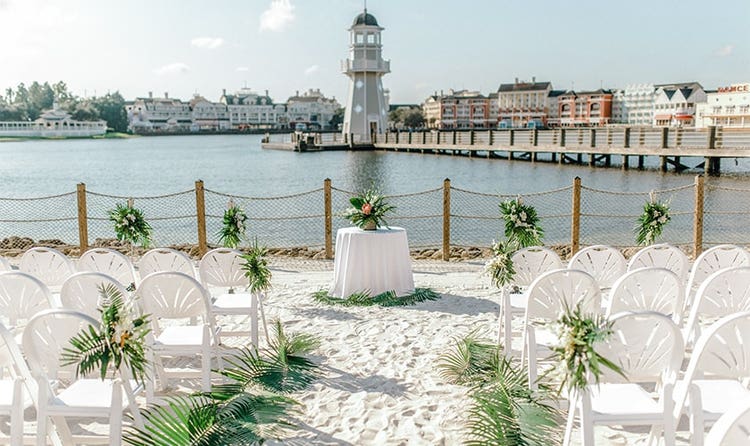 A round table on a beach in front of a lighthouse and Disney's BoardWalk
