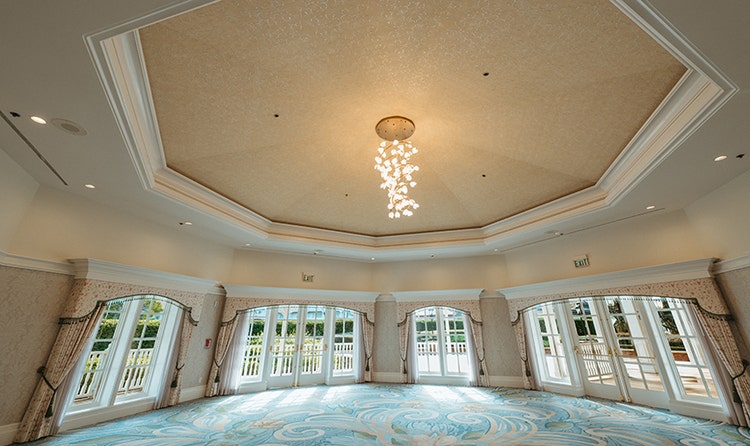 A round ballroom with windows and a door leading out to a deck