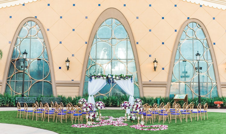 Chairs arranged on lawn facing a large building with many windows and floral decorations