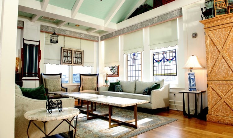 A seating area at The Attic in Disney's BoardWalk Inn featuring couches and chairs against windows